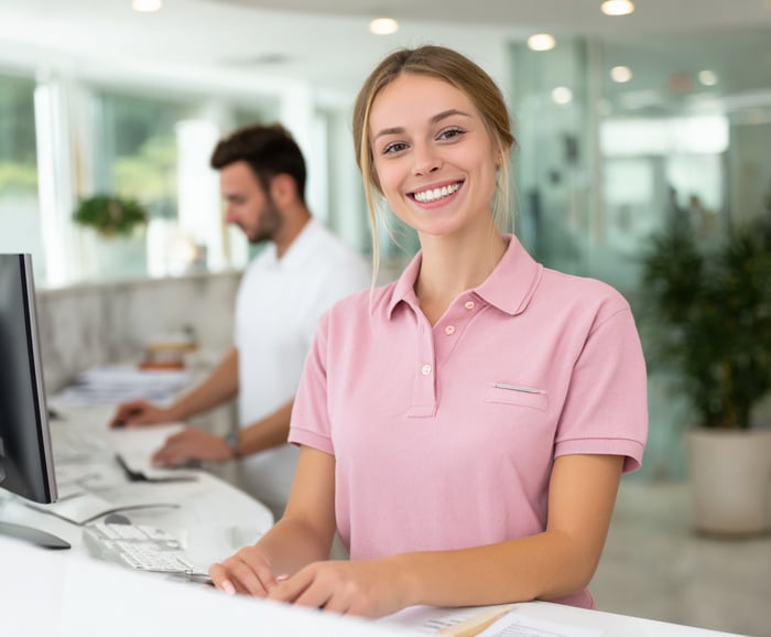 u3988972358_smiling_female_receptionist_in_pastel_pink_polo_s_4b4311f2-2ced-4fe2-b650-a9f91f3467dd_3